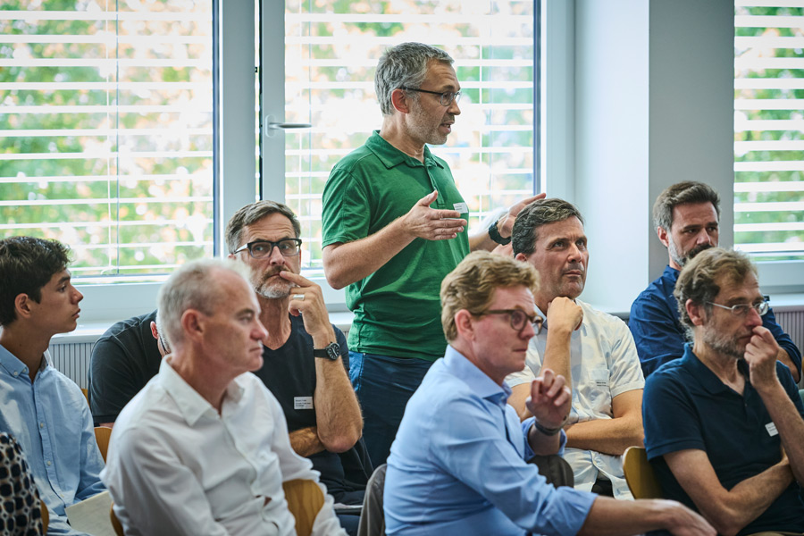 Wolfram Kübler, Partner at WaltGalmarini, speaks. Matthias Eisele, Partner at merz kley partner, Markus Schäfer, Partner at Hosoya Schaefer Architects, and Bernhard Egert, Head of Timber Construction and Green Building at UBM Development, listen.